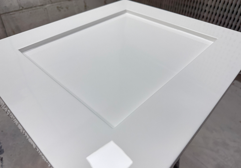 Spray finished cabinet door panel laid flat showing smooth painted surface before installation