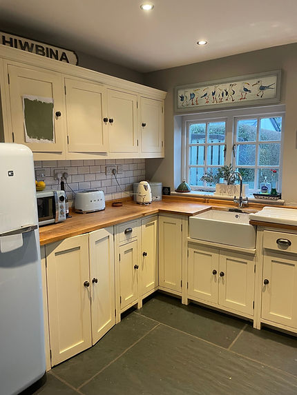 Before photo of a kitchen refinishing showing original cream cabinetry updated to soft green with restored oak worktops in Rhiwbina Cardiff