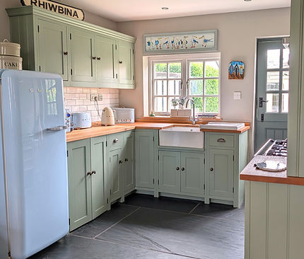 after kitchen refinishing showing original cream cabinetry updated to soft green with restored oak worktops in Rhiwbina Cardiff