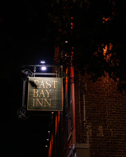Entry sign outside East Bay Inn at night