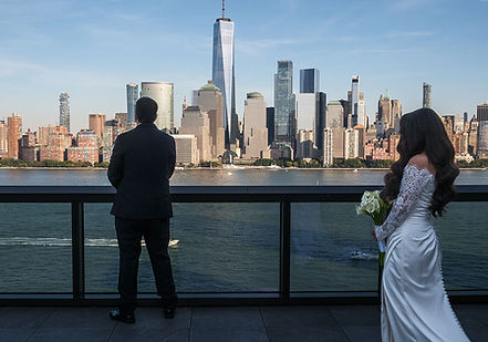 Bride approaching groom during first look with New York City skyline across the Hudson River.