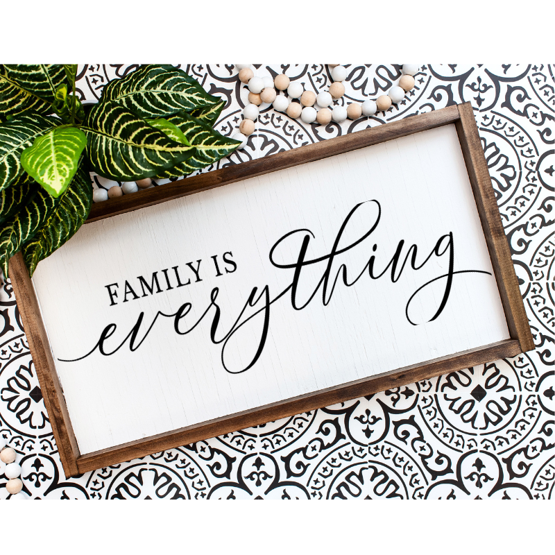 Minimalist wooden sign reading family is enough, displayed in a warm, cozy home setting.