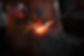 The blacksmith manually forging the molten metal on the anvil in smithy with spark firewor