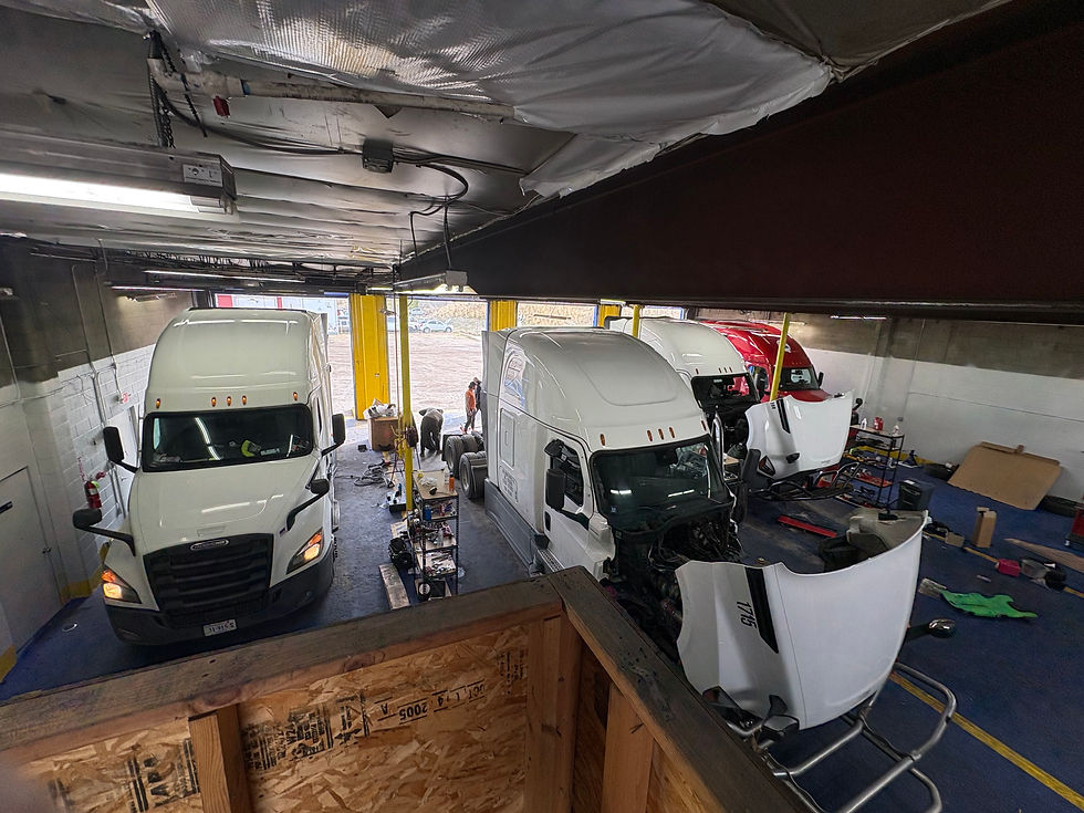 Interior shot of busy truck repair bay with semi trucks being serviced