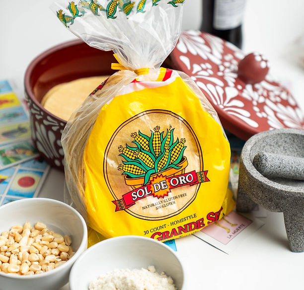 Yellow corn tortillas in a package with a tortilla warmer behind it.