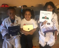 Children with their copies of "Clunker the Clumsy Caribou" and "What I Love About Christmas" books.