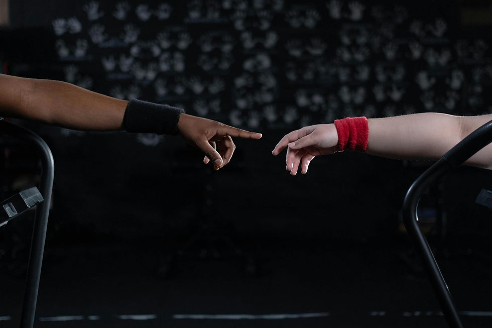 two arms reaching across a dark space seeking support from each other
