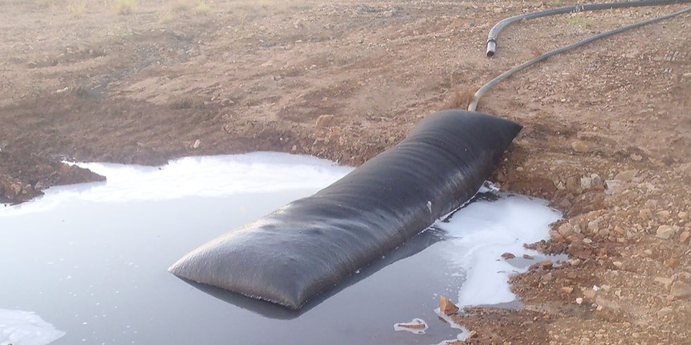 Dewatering bag in action, connected to a pump hose and draining water while containing sediment.