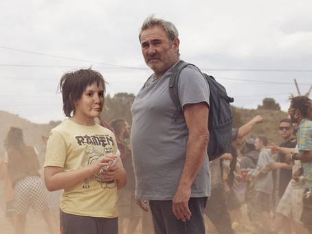 Luis and his young son, a boy of around 10, Esteban from the 2025 film Sirât. They stand, out of place, amidst a crowd at a desert rave. My face is superimposed over Esteban's.