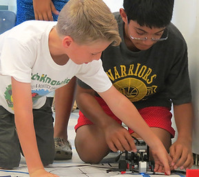 Two kids working on their motorized LEGO builds