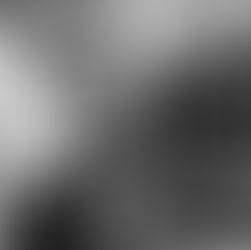 Two men smiling near a car in a bright showroom. One wears a white shirt, the other a blazer. The mood is cheerful and casual.