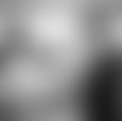 Man and woman smiling and shaking hands in a bright showroom with a car in the background, conveying a positive and professional mood.