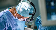 A surgeon performing a urinary diversion with cystectomy to treat complications of genitourinary syndrome of menopause