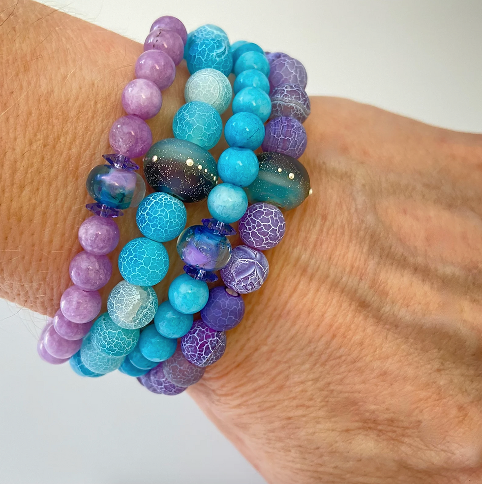 gemstone and lampwork bead bracelets on a woman's wrist