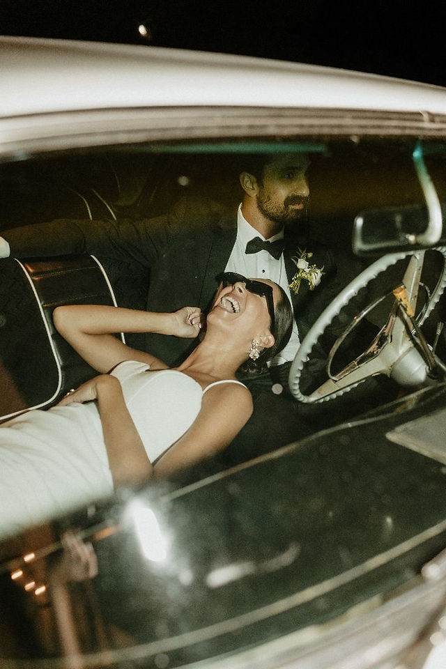 A grand entrance, such as a couple arriving in a vintage car