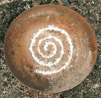Mehlspirale neben einer Feuerstelle in einem Frauenkreis.
