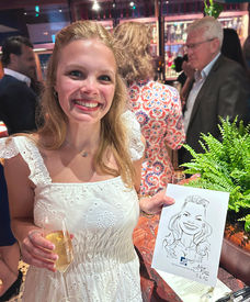 Corporate drinks party guest holding up her caricature by Alfie Delish