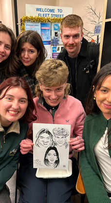 Workspace staff having their group caricature drawn at a Christmas office party