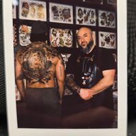 polaroid photo of tattoo artist Timothy Strange from One Two Tattoo from Mississauga GTA Toronto inside a tattoo studio with a completed backpiece tattoo on a client he executed