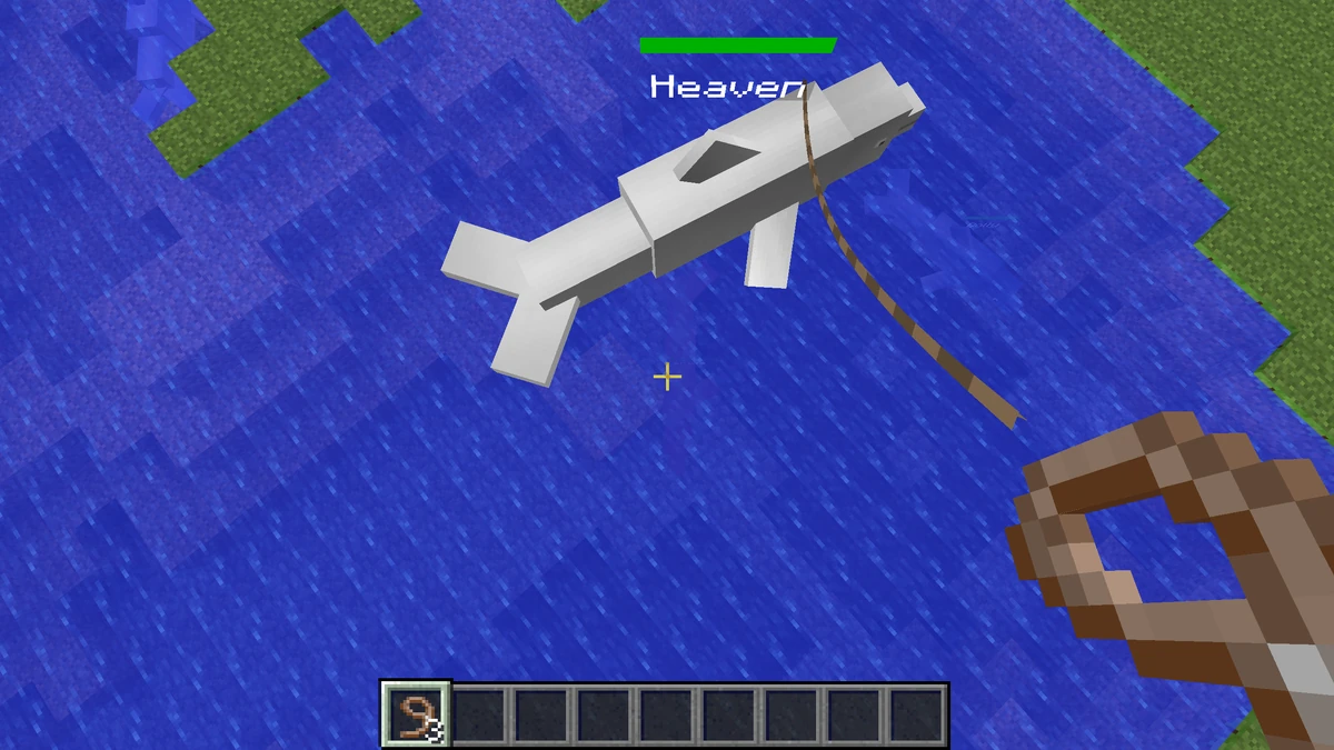 Aerial view of a pod of dolphins swimming near seagrass and a shipwreck in Minecraft.