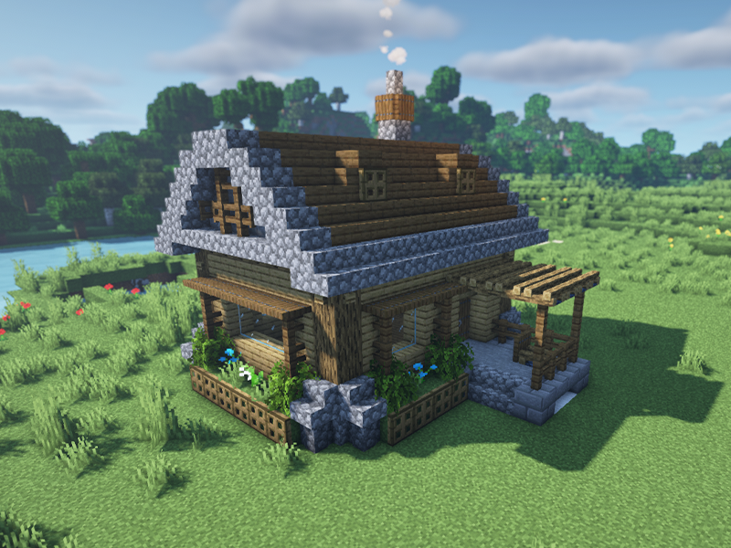 A beautifully designed cobblestone house surrounded by lush greenery in Minecraft.