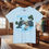 Thumbnail: Light blue t-shirt with image and text: Alaska the Last Frontier. Wolf's Den Clothing.