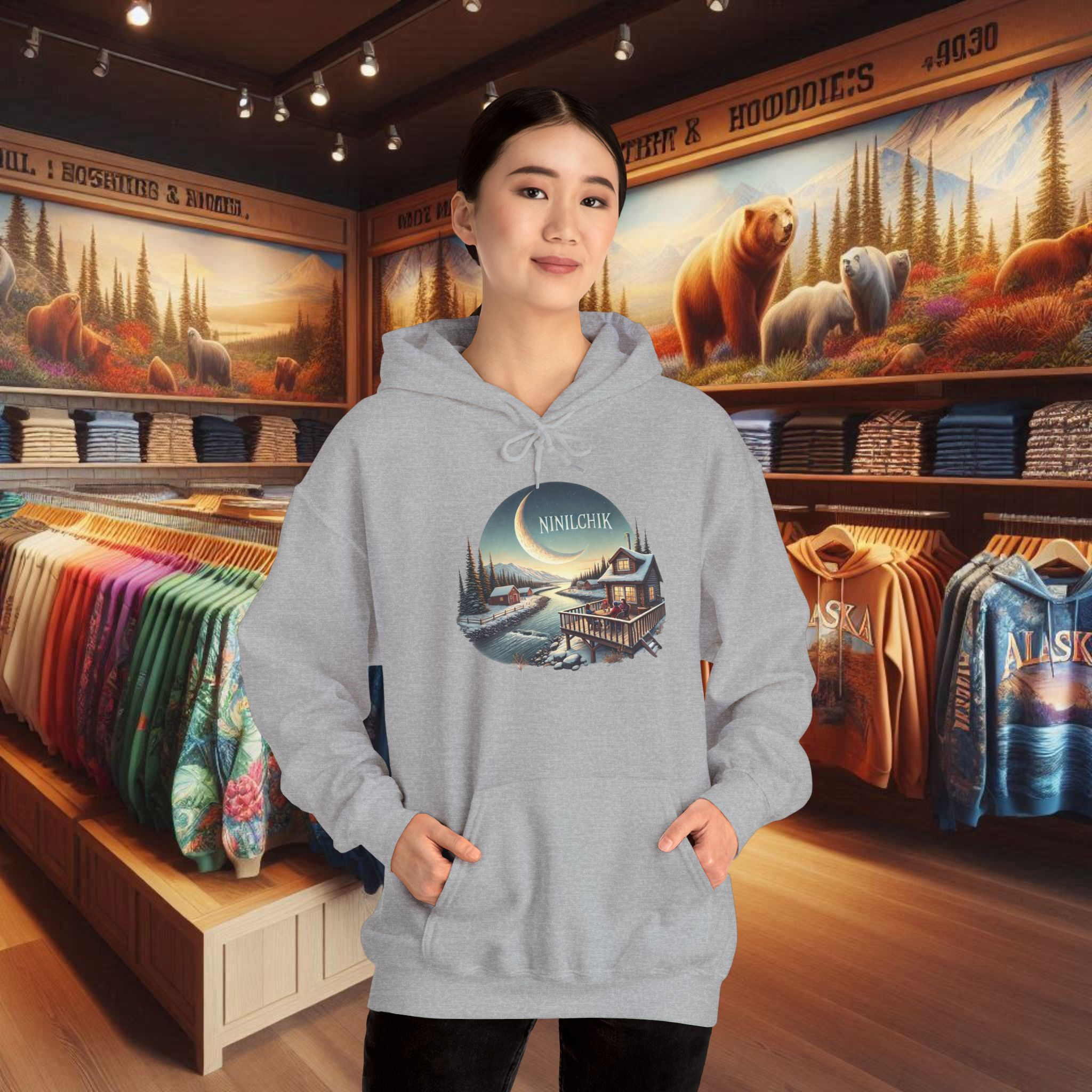 Woman in grey hoodie with Ninilchik Alaska log cabin graphic