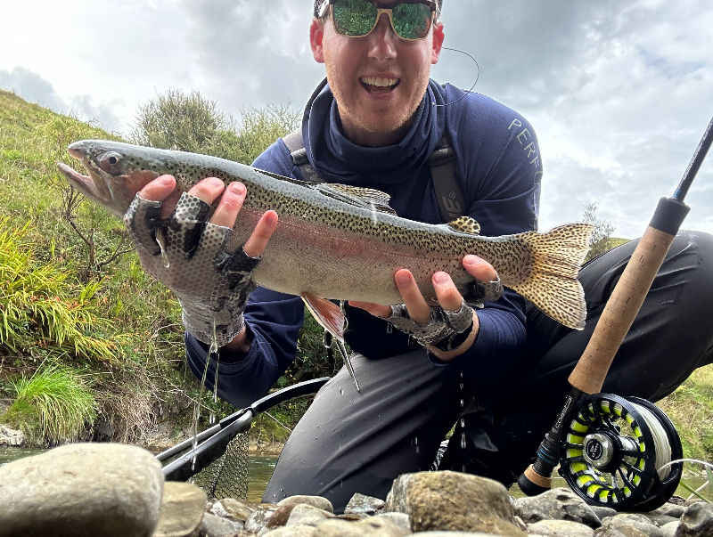 Guest holding a freshwater fish near Ripples Retreat in New Zealand.