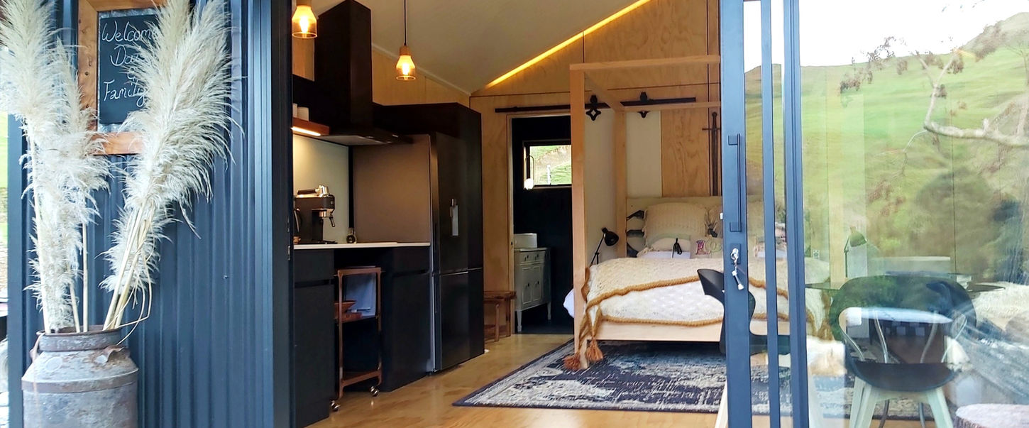 Open cabin living space overlooking the countryside at Ripples Retreat near Waitomo.