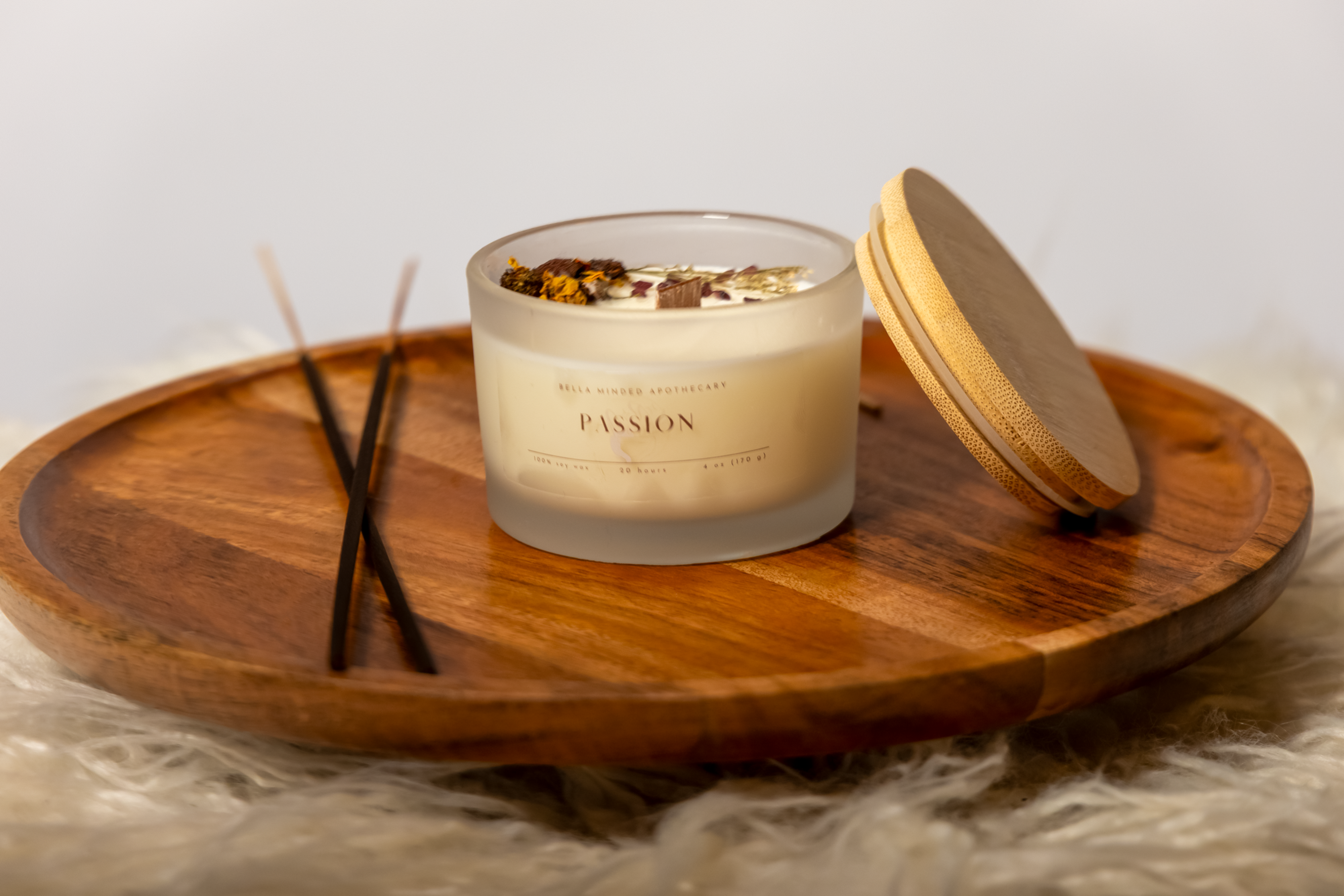 Candle centered on wooden centerpiece placed on textured surface with neutral background