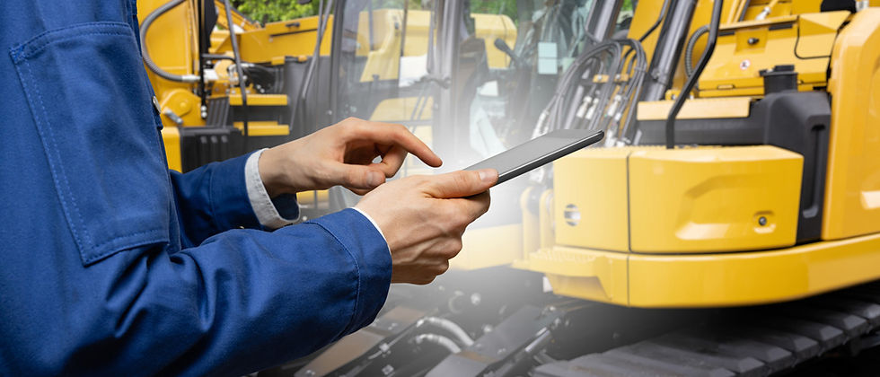 Person in blue jacket using a tablet in front of yellow construction machinery. Background is industrial, focused on technology interaction in Fort Lauderdale, FL.
