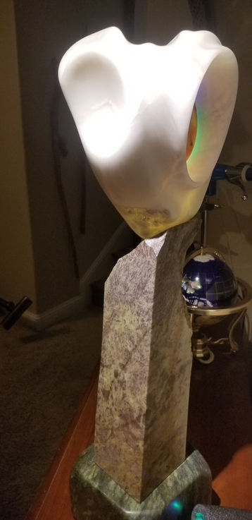 Perched on a green soapstone base the Portal Key is a red Utah alabaster disc that hovers within a protective Italian Ice alabaster vessel. This otherworldly piece comes with a warning and a waiver needs to be signed. If the colors synchronize and you place your hand on it just right you could be teleported to, who knows where? 
33" T x  10" W x 9" D 