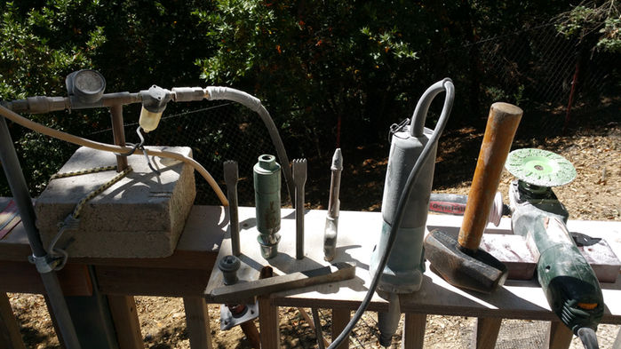 Various tools sit on wooden table; Tools of the Trade used for construction work.