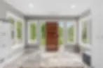 Eye-level view of a bright and organized entry hall with built-in storage and bench