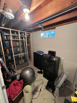 Basement interior before renovation following roof damage by 1st Call Construction & Exteriors in Minnesota, showing exposed framing prior to remodel.
