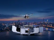 DJI Dock 4 no topo de um edifício ao anoitecer, com o Matrice 5TD em voo sobre a cidade