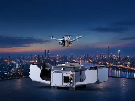 DJI Dock 4 no topo de um edifício ao anoitecer, com o Matrice 5TD em voo sobre a cidade