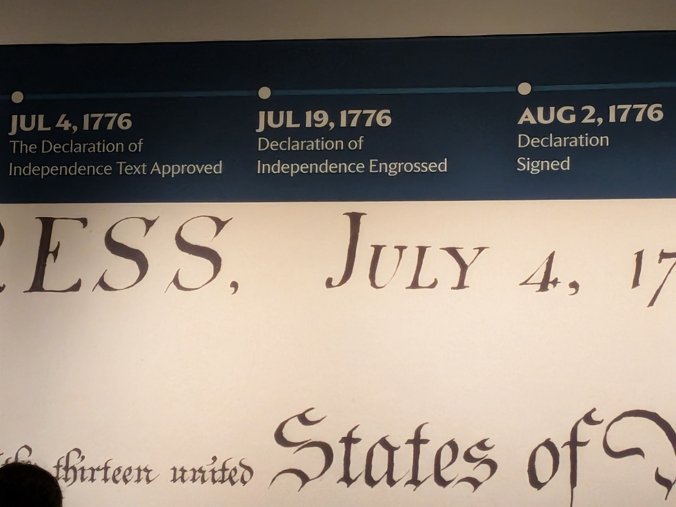 Museum exhibit timeline of the Declaration of Independence with dates Jul 4, Jul 19, and Aug 2, 1776 above a giant manuscript page