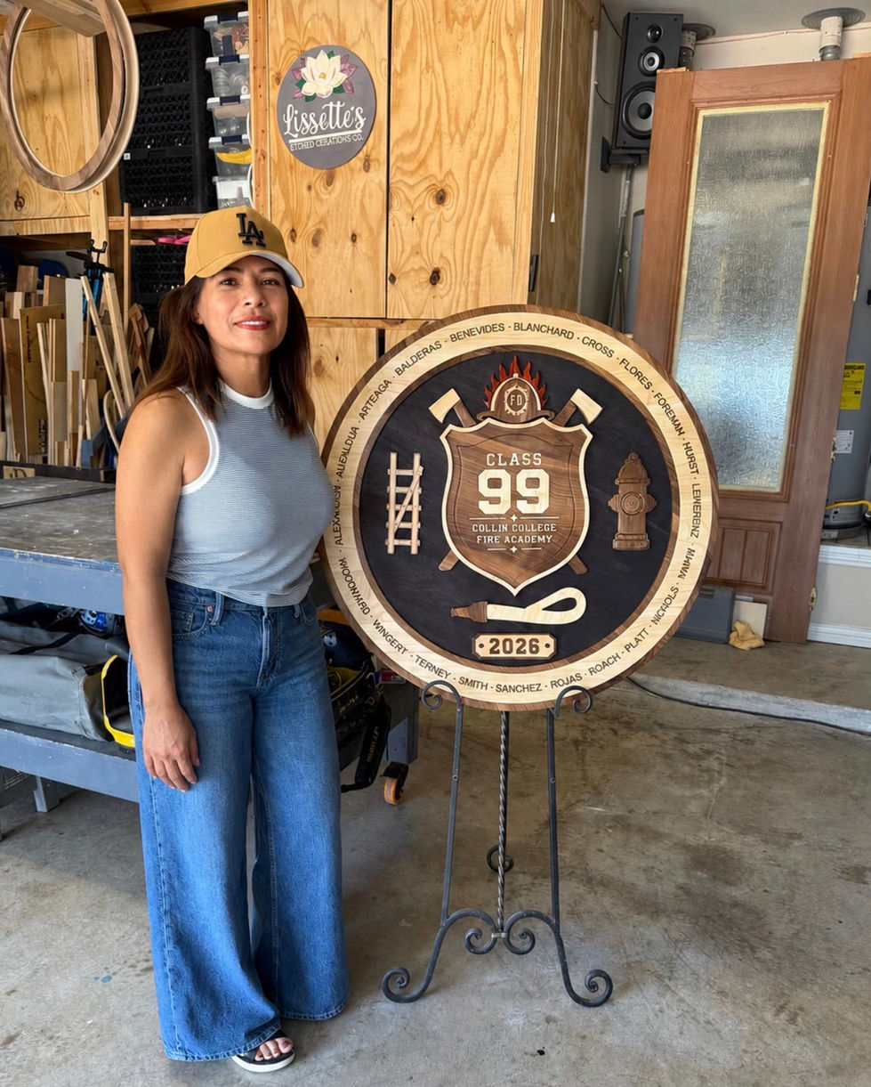 Woman standing beside a circular wooden sign.