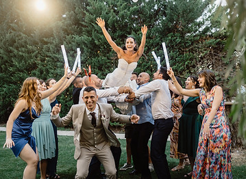 Novia lanzada por los aires por las amigas el día de su boda. Felicidad, y risas.