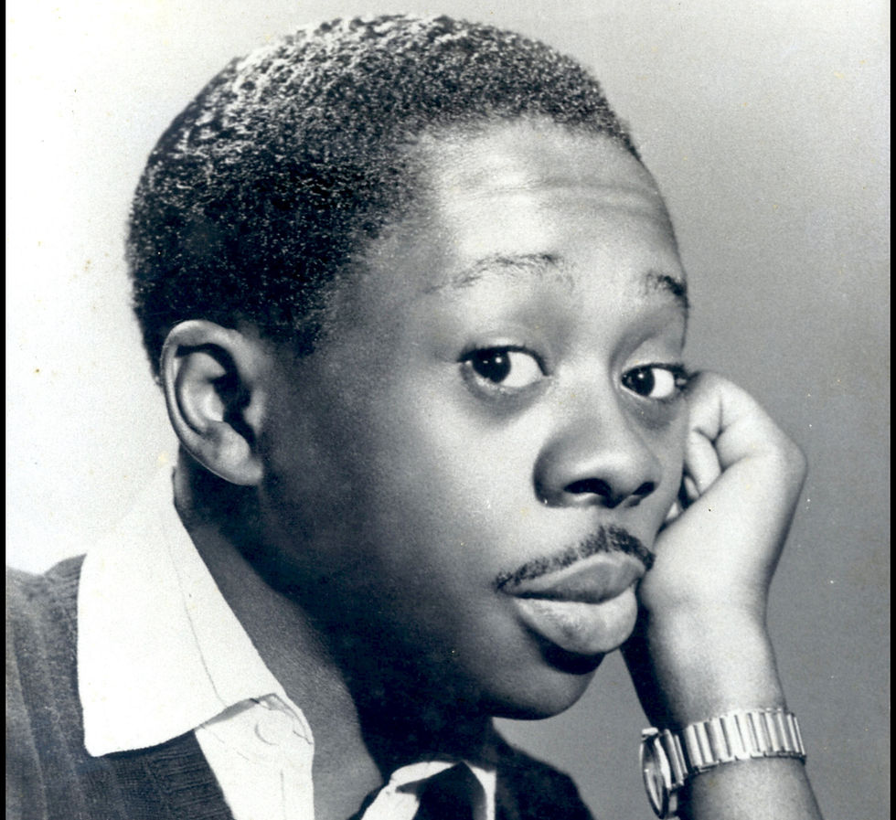 Foto em preto e branco de Grande Othelo jovem. Ele posa com a mão esquerda na bochecha.