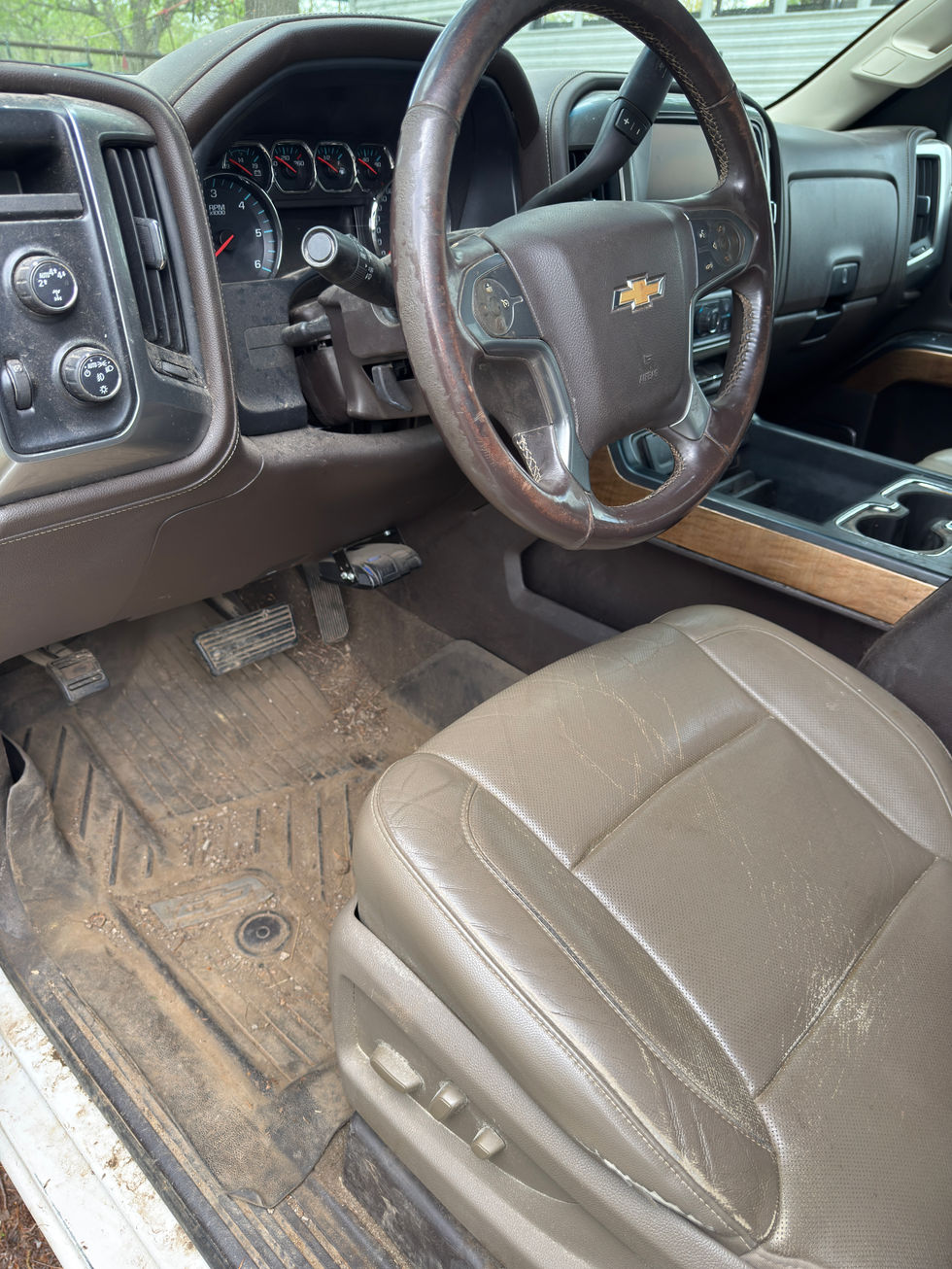 Car interior with steering wheel and seat visible.