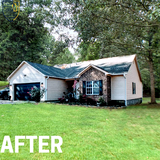 White home with stone accent, small planter and green grass