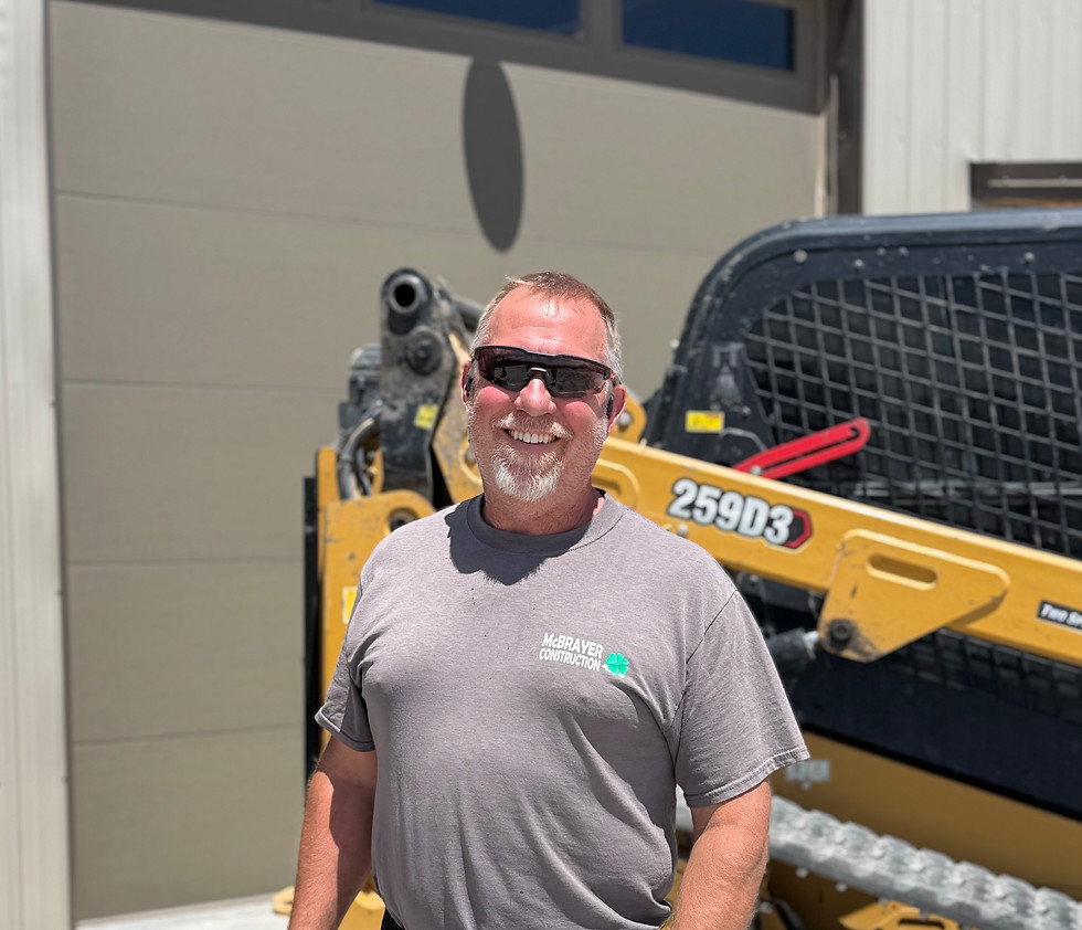 Eric McBrayer, owner of McBrayer Construction, standing in front of Cat 259D3 skid steer