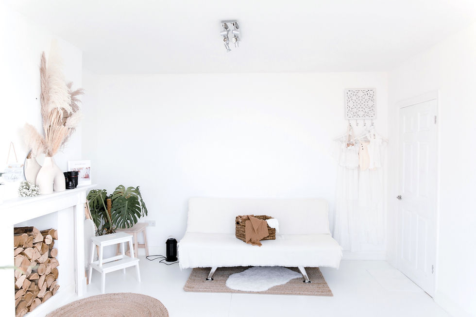 cosy white photo studio in gravesend kent, white sofa and fireplace filled with decorative wood