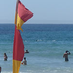A red and yellow flag with an ocean background