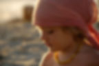 Adorable enfant au bandana rose, collier ambre