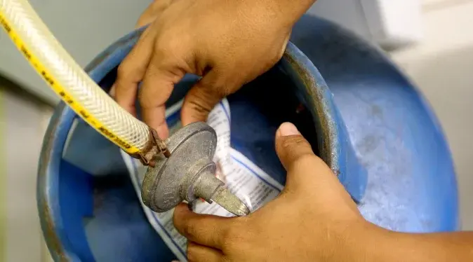 troca de gás de cozinha com um botijão ultragaz azul