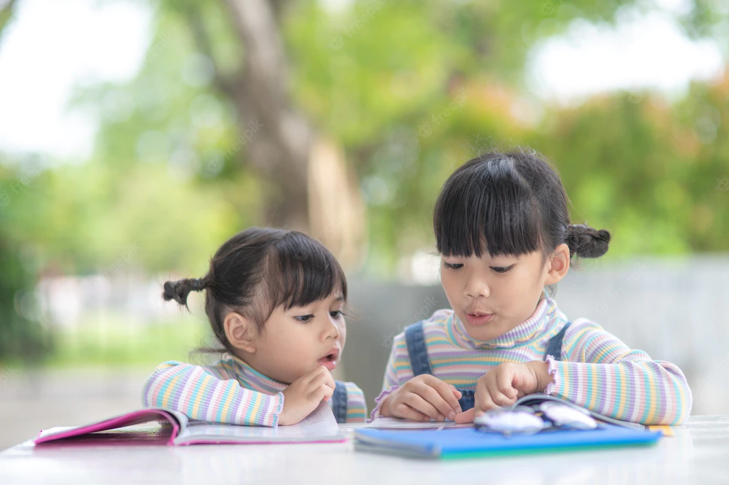two-student-little-asian-girls-reading-book-table_29488-1952.webp