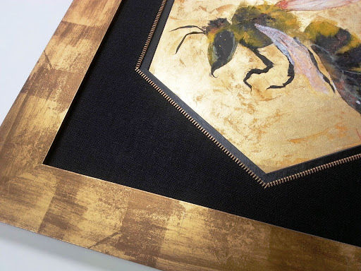 Close-up detail of hexagonal bee artwork frame showing zipper accent and layered textures.